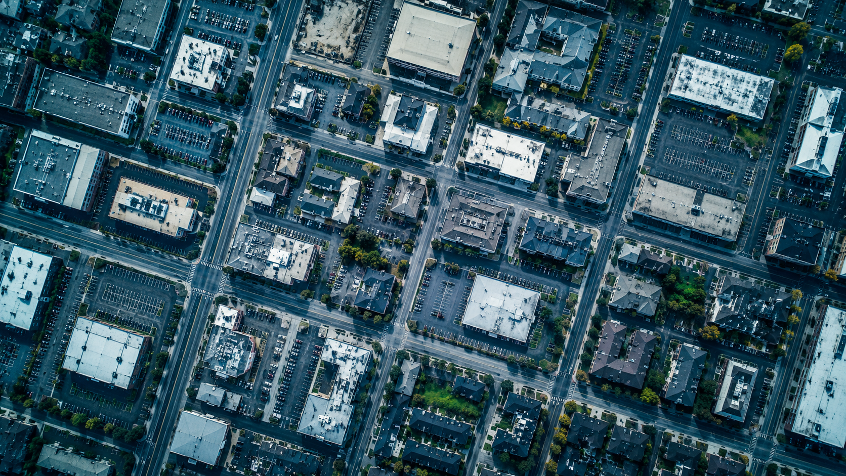 Aerial overhead view of a multi-block commercial district, used as a visual cue for fragmented portfolio operations.
